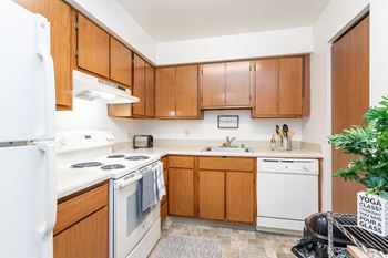 A kitchen with white appliances and wooden cabinets